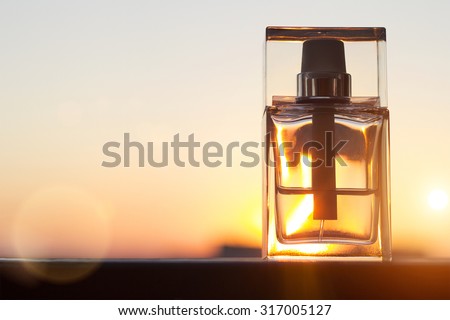perfume bottle on gold sunset background with copy space.