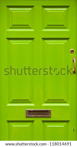 green typical residential house door in Ireland (golden lock, handle and mailbox)