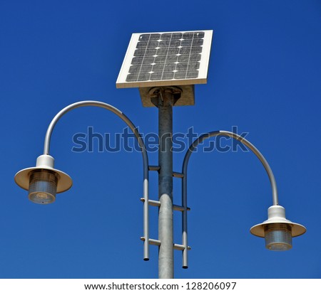 street lamp post with solar panel energy against blue sky background