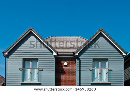 detached british residential house (beach style) with window baconies (blue sky)