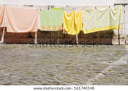 typical Lisbon sidewalk view with clothes drying outside (copy-space available on the portuguese stone pavement)