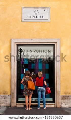 ROME - SEPTEMBER 18: unidentified women looking at Louis Vuitton show window at Via dei Condotti in Rome, Italy on September 18, 2013. It has been named the world\'s most valuable luxury brand.