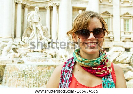 beautiful smiling woman tourist at the famous Trevi Fountain in Rome, Italy