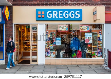GLOUCESTER, UK - DECEMBER 04: unidentified woman leaving Greggs bakery shop on December 04, 2011 in Gloucester, UK. Founded in 1939, Greggs is the largest bakery chain in the UK with 1,671 outlets.