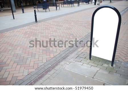 empty billboard at a urban commercial street with red tiled pavement and benchs on background