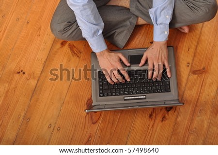 man with laptop computer sitting on the floor at home