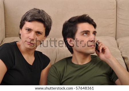 frustrated woman being ignored by a man talking on the cell phone