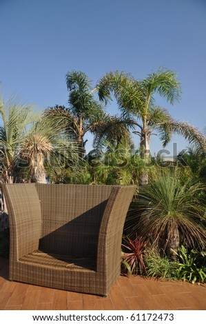 outdoor hotel decoration with relax sofa and tropical trees at the background
