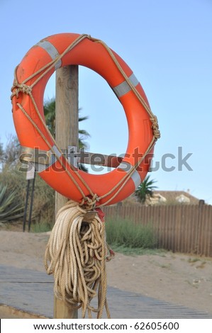 orange buoy foam lifesaving ring at the beach (sunset picture)