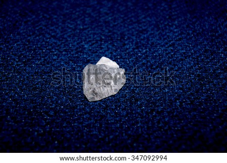 Pure quartz gemstone on blue background