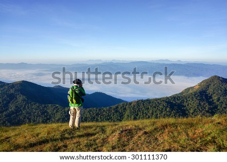 Chiang Mai, Thailand - Dec 10, 2012 : Tourist Group hiker with backpack on top of the mountain and enjoying valley view