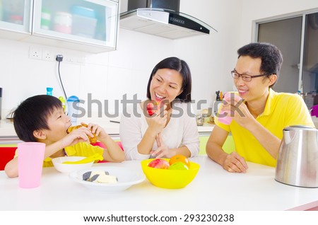 Happy asian family having breakfast in the kitchen