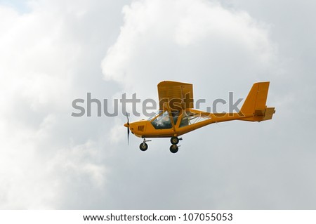 Flying private propeller-driven airplane over cloud sky