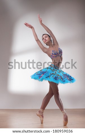 beautiful woman ballet dancer on grey window-light background