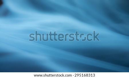 wavy fabric or blue background abstract cloth or liquid waves illustration of wavy folds of silk texture satin or wallpaper design of elegant curves material or defocused wavy background