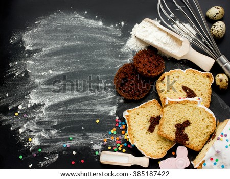 Easter bunny cake preparing in kitchen. Holiday food background with creative cake and baking ingredients on black background top view with copyspace