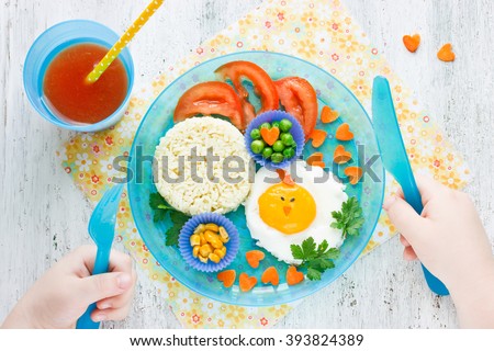 Concept of healthy food for child. Food art idea for kids breakfast egg and vegetable garnish tomato juice top view