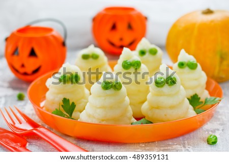 Mashed potatoes ghosts with green peas eyes, hot dinner dish for Halloween, fun food for kids