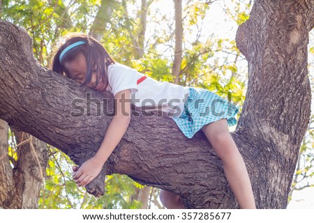 Close up asian children climbing trees are afraid of falling trees.