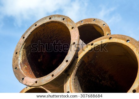 Rusted industrial steel pipes on the blue sky background.