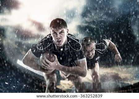 Sports, game, fighting - Rugby players on a stadium in the rain