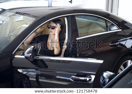 Sexy woman in luxury car with long legs
