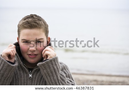 Teenager boy looking at camera in cold weather with sweater look for more o the same model