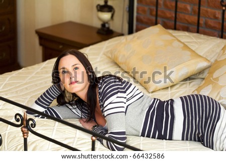 Young women lying on bed with secret in her eyes