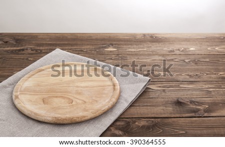 Background for product montage. Empty round wooden board with tablecloth.