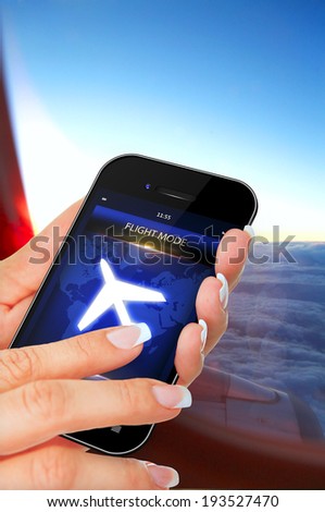 closeup of hand holding mobile phone with flight mode in the airplane