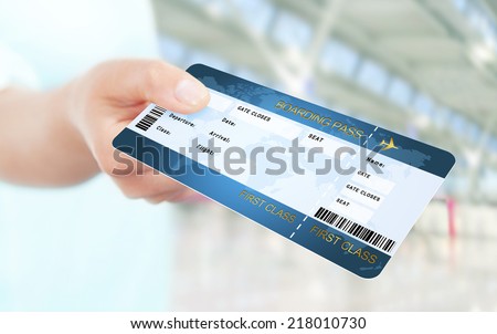 first class flight ticket holded by hand. focus on ticket