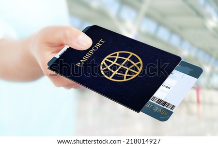 first class flight ticket and passport holded by hand. focus on ticket and passport