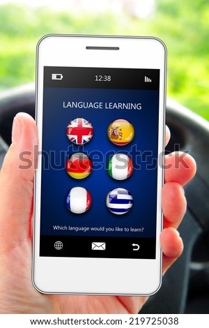 hand holding mobile phone with language learning application in the car
