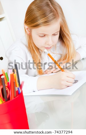 small smiling girl painting picture on table