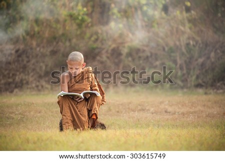 Sakon Nakhon - Apr 4: Unidentified young novice monks study in the field  on Apr 4  in Sakhon Nakhon,Thailand. Southeast Asian neophyte reading in a field.