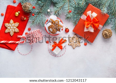 Merry Christmas background with traditional decoration. Red ribbons on gift boxes, cookies. Winter holidays concept. Copyspace, overhead shot.