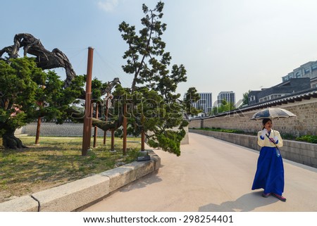 SEOUL, SOUTH KOREA - CIRCA APRIL 2014: Female Korean tour guide in a traditional clothing conducts a tour for tourist group in Seoul, Korea circa 2014.