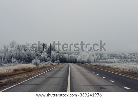 MOSCOW REGION, RUSSIA - NOVEMBER 7: empty road with trees in hoarfrost and foggy weather in the morning in Moscow region suburbs on the November 7th 2015.