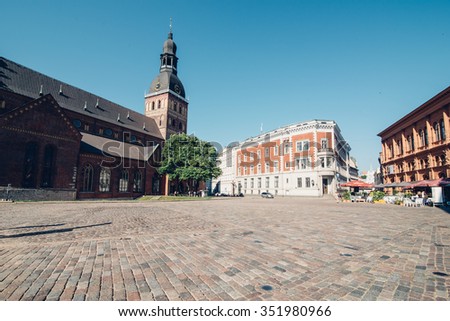 RIGA, LATVIA - CIRCA JULY 2014: old square with church in the old town in Riga, Latvia on a sunny warm day in July 2014.