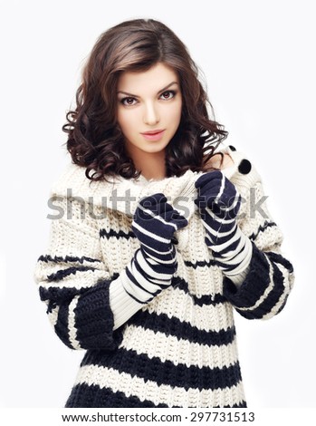 Photo of a young woman wearing colored sweater with  knit gloves and scarf.