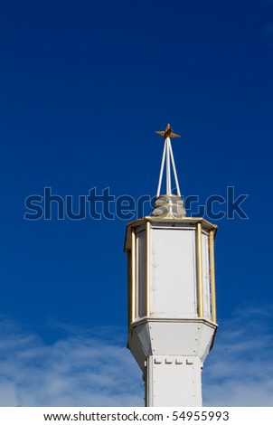 Deco White and Gold Lamp with star on top against deep blue sky