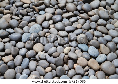 Large bed of gray and dark blue smooth river rock