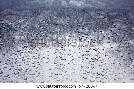 Rain drops on a waxed silver car hood