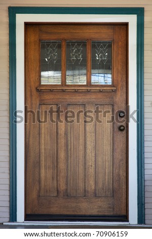 Craftsman deco style window in mission style stained wood door with green and white trip