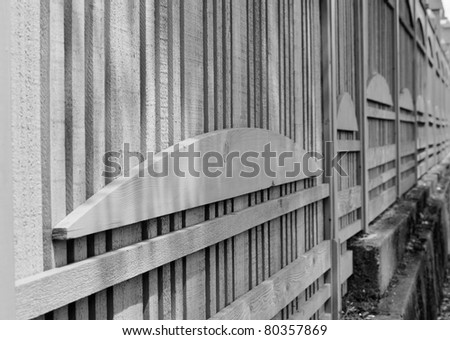 Black and white image of a unique design wood fence in diminishing perspective