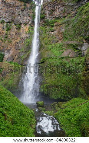 Long thin water fall against a moss covered cliff face