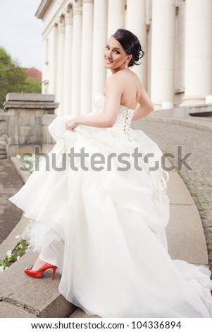 Beautiful bride standing with wedding dress smiling at camera