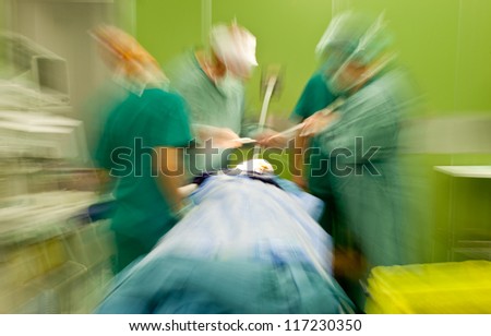 Blurred figures of doctors in medical uniforms performing brain surgery on patient