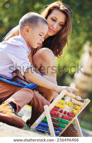Mother teaches her son mathematics in the park