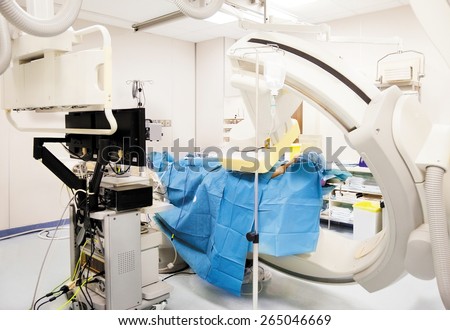 white sterile surgery room with c-arm x-ray scanner, pointing at a patients neck